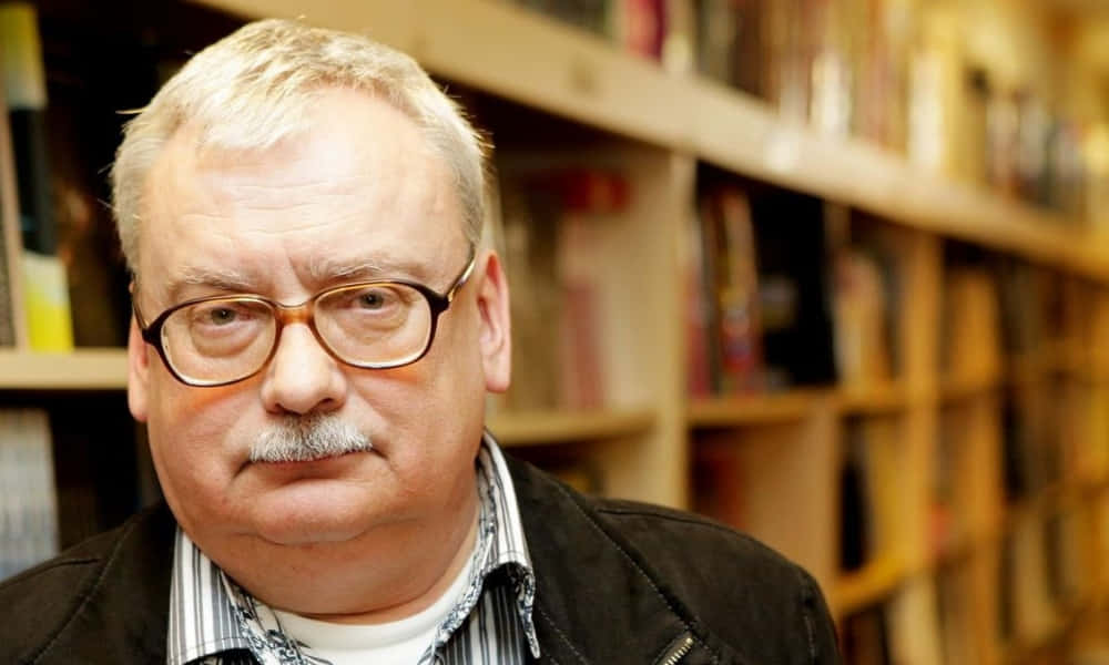 Andrzej Sapkowski Posing With His Books Wallpaper