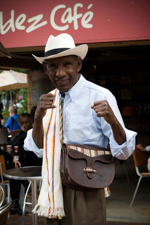 Antonio Cervantes Wearing A White Suit And Fedora Wallpaper