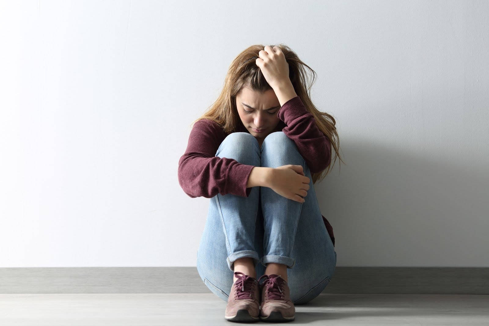 Anxious Woman Sitting On Floor Wallpaper