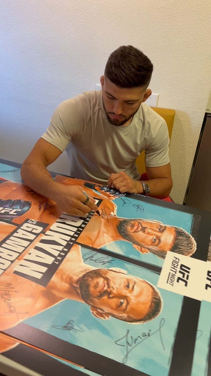 Arman Tsarukyan Engrossed In Signing Posters Wallpaper