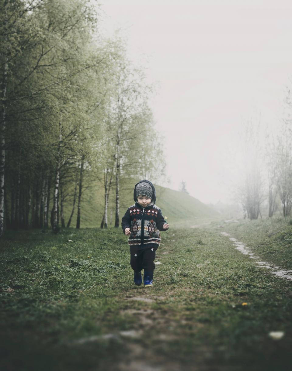 Baby Boy Walking On Grassy Landscape Wallpaper