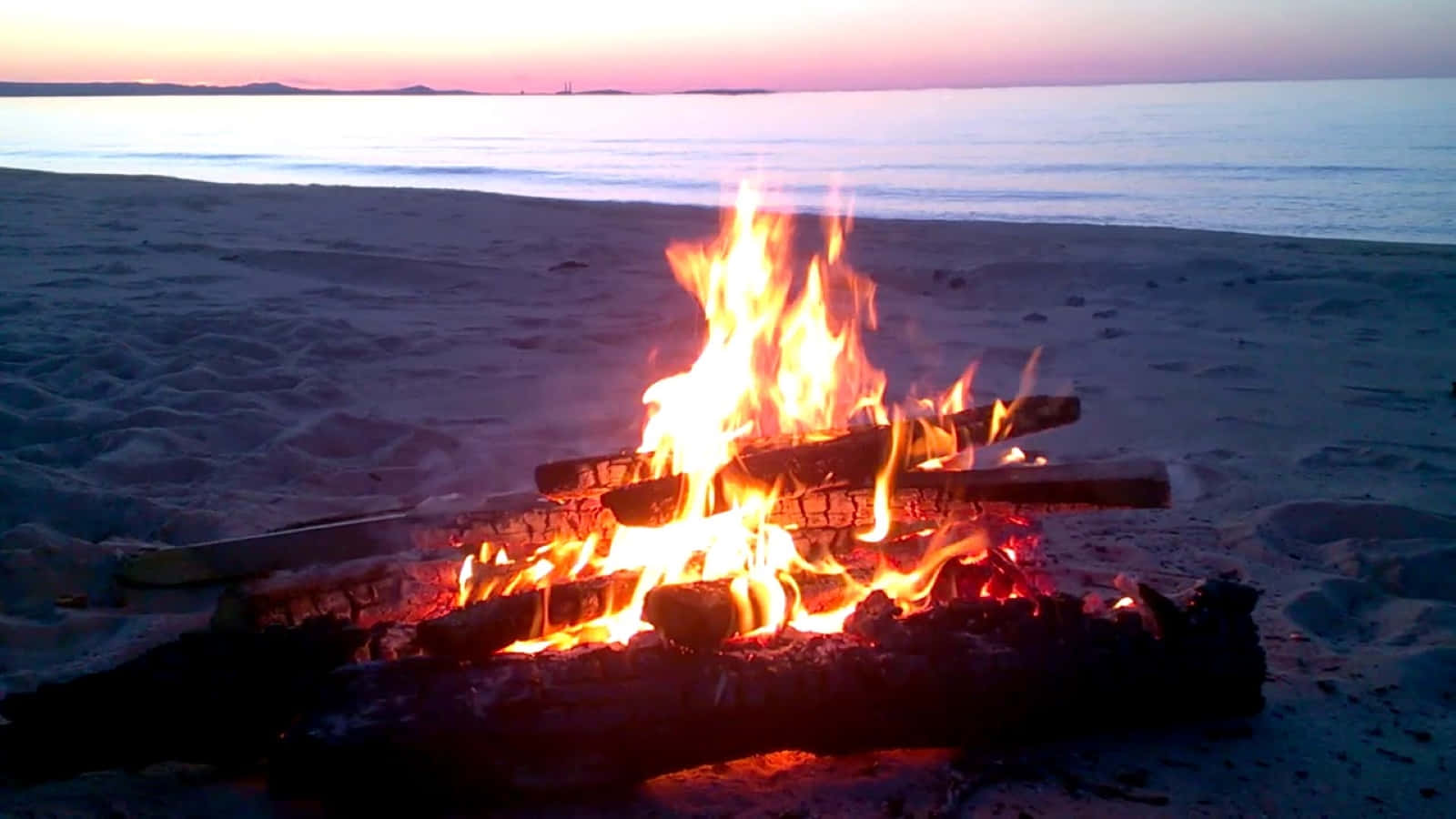 Beach Bonfire Under A Starry Night Wallpaper