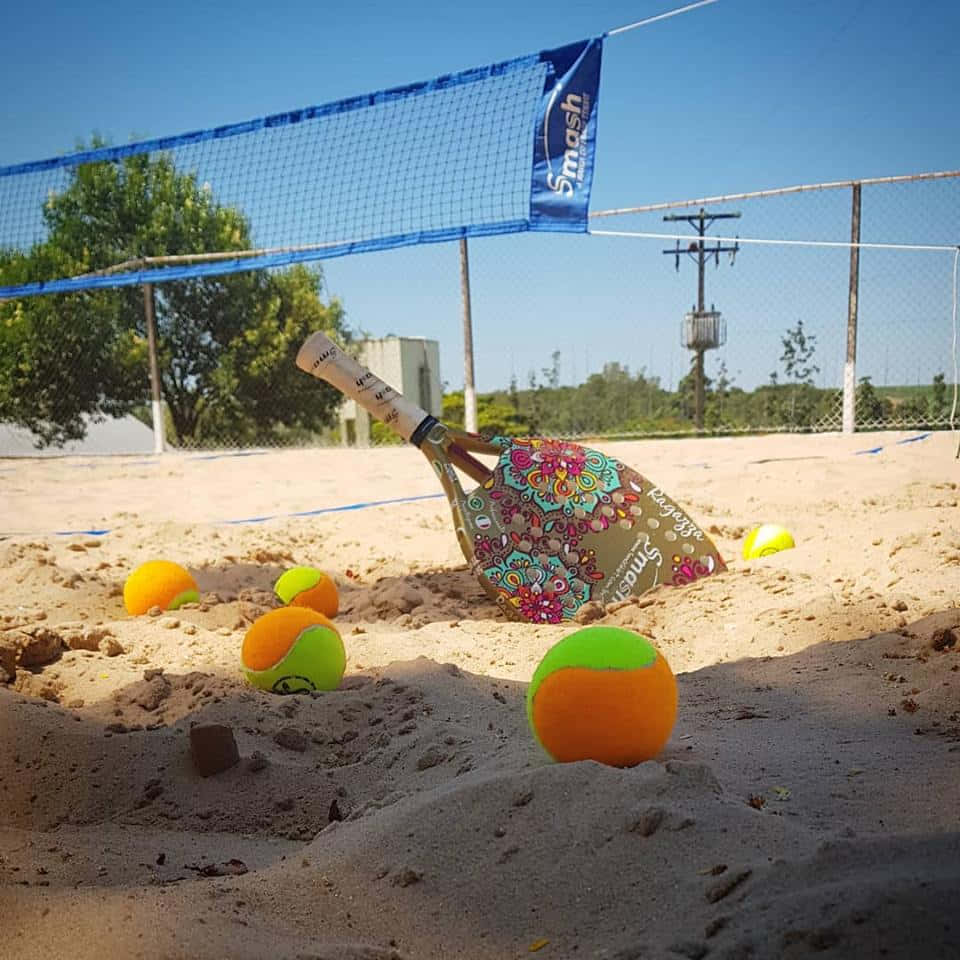 Beach Tennis Action: Players Having Fun On The Sand Wallpaper