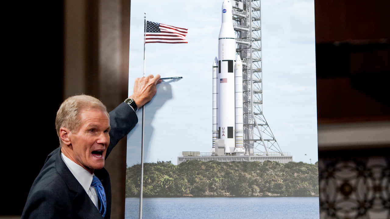 Bill Nelson Pointing At A Nasa Rocket Wallpaper