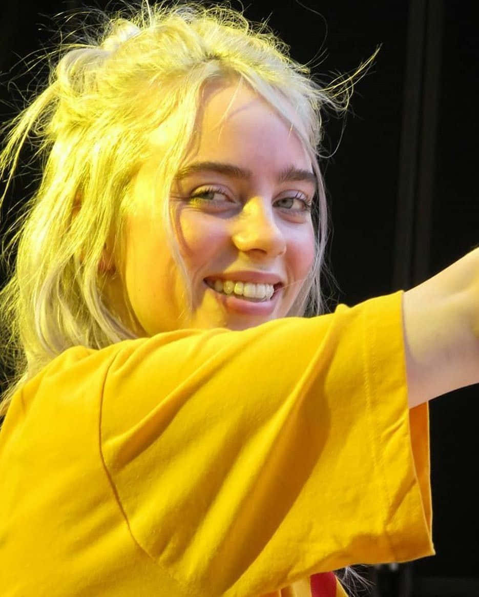 Billie Eilish Smiling Onstage Wallpaper