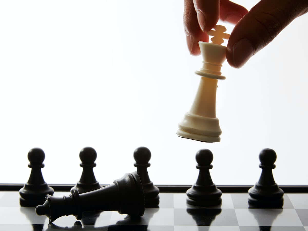 Black And White Chess Board With Pieces Strategically Arranged Wallpaper