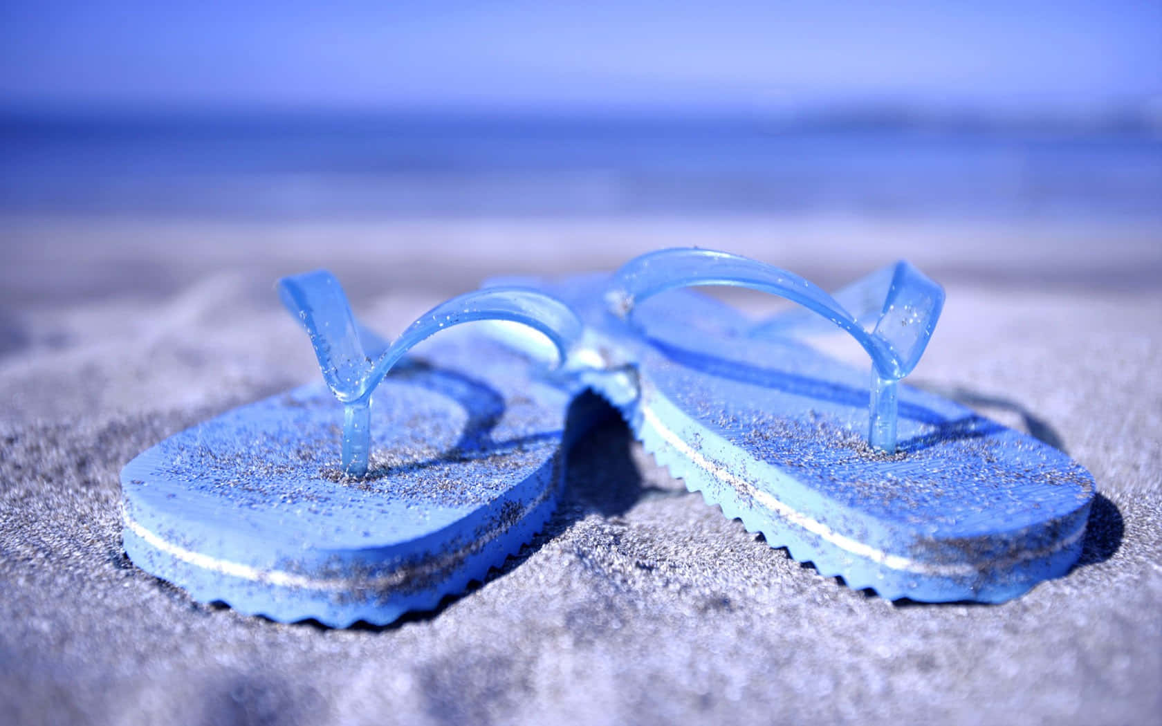 Blue Flip Flopson Beach Sand Wallpaper