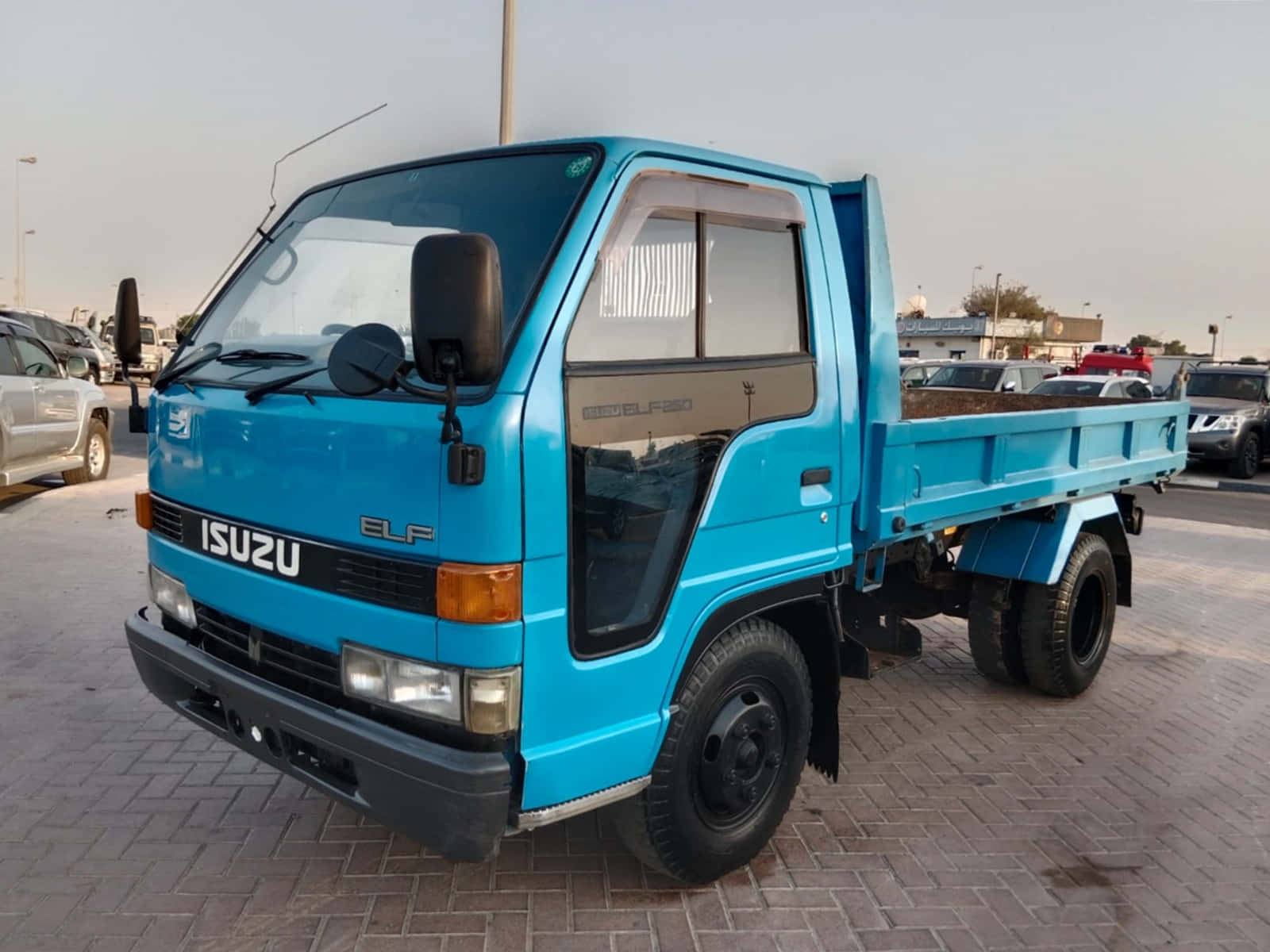 Blue Isuzu Elf Truck Parked Outdoors Wallpaper