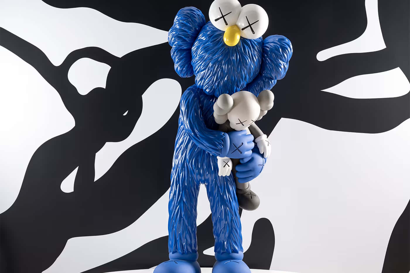 Blue Kaws Figure Holding Smaller Character Wallpaper