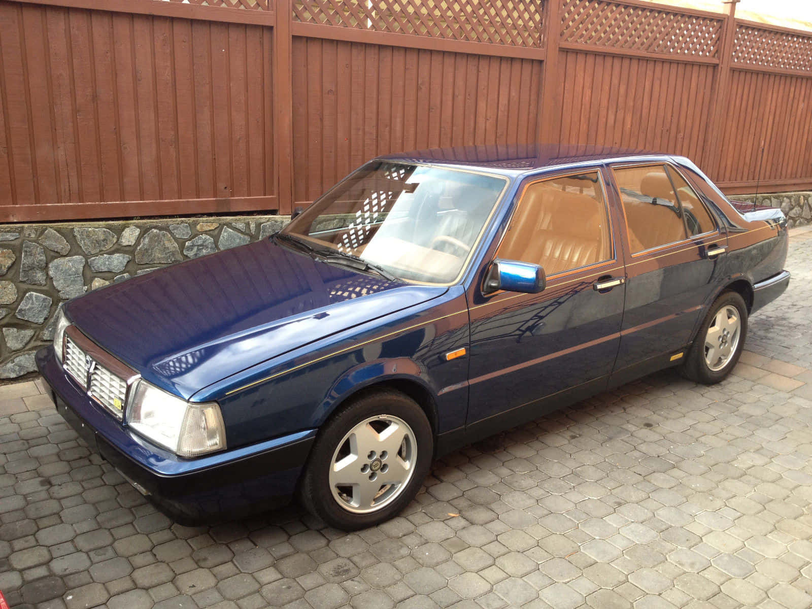 Blue Lancia Thema Parked Outdoors Wallpaper