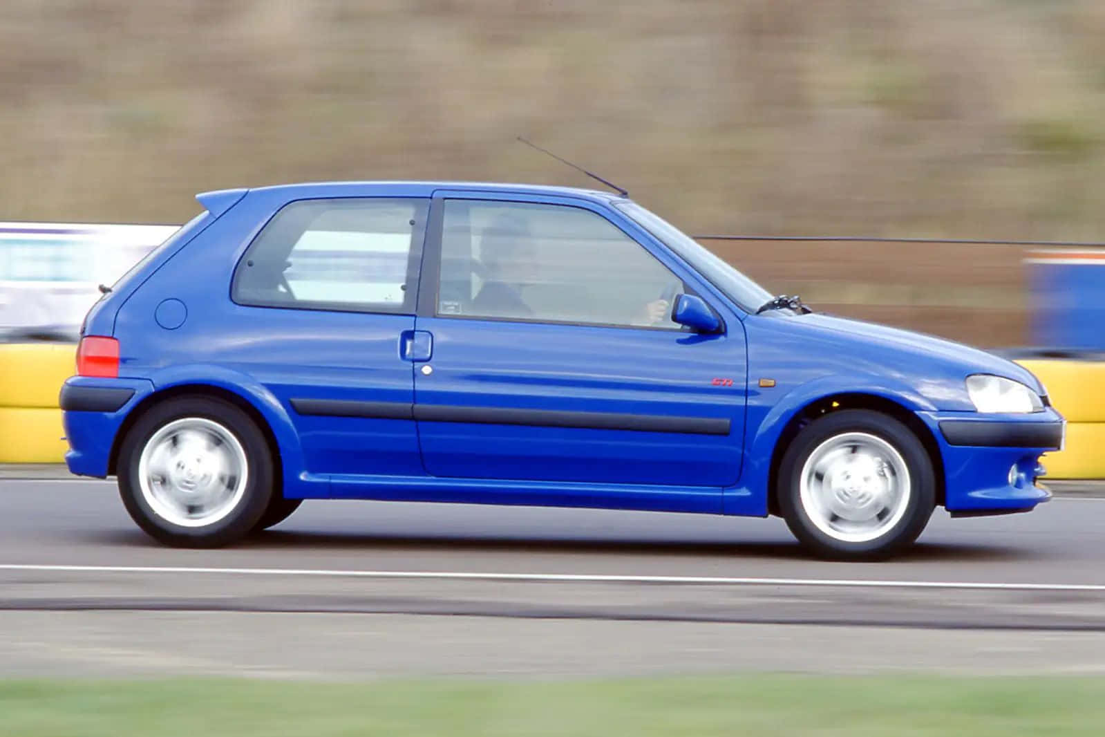 Blue Peugeot106in Motion Wallpaper