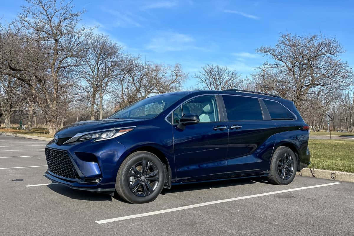 Blue Toyota Sienna Parked Outdoors Wallpaper