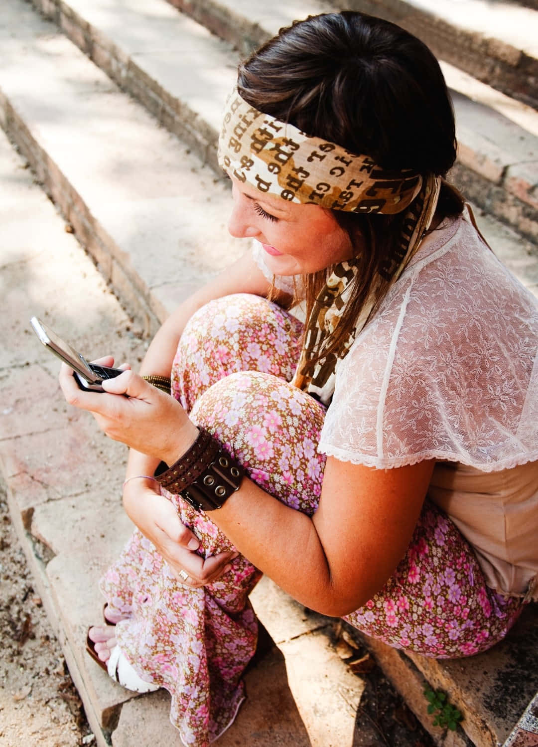 Boho Chic Woman Using Phone Outdoors Wallpaper