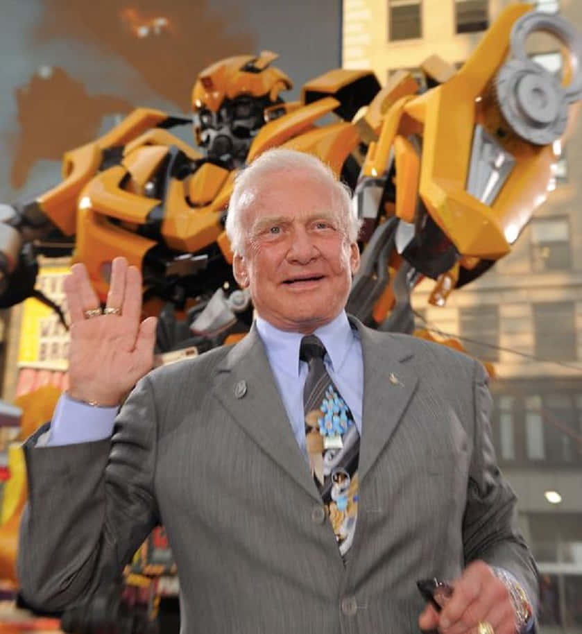 Buzz Aldrin Wavingin Frontof Transformer Wallpaper