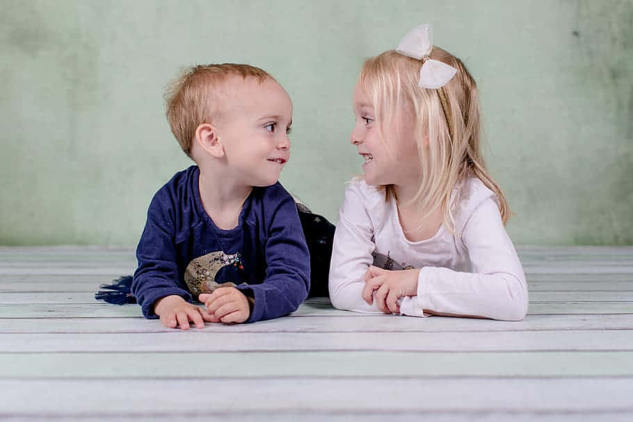 Candid Photography Of A Boy And His Cute Sister Wallpaper