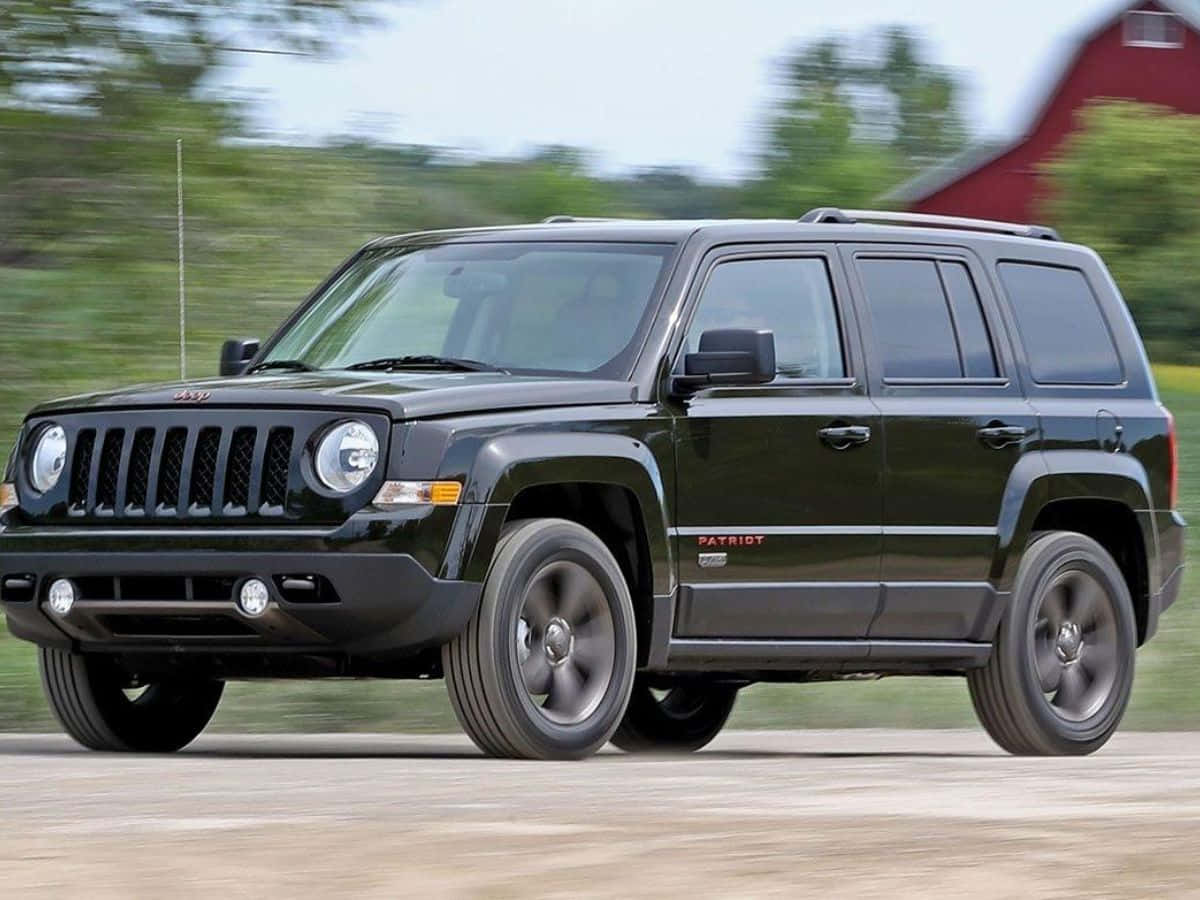 Caption: Adventure Awaits - Jeep Patriot On Rugged Terrain Wallpaper