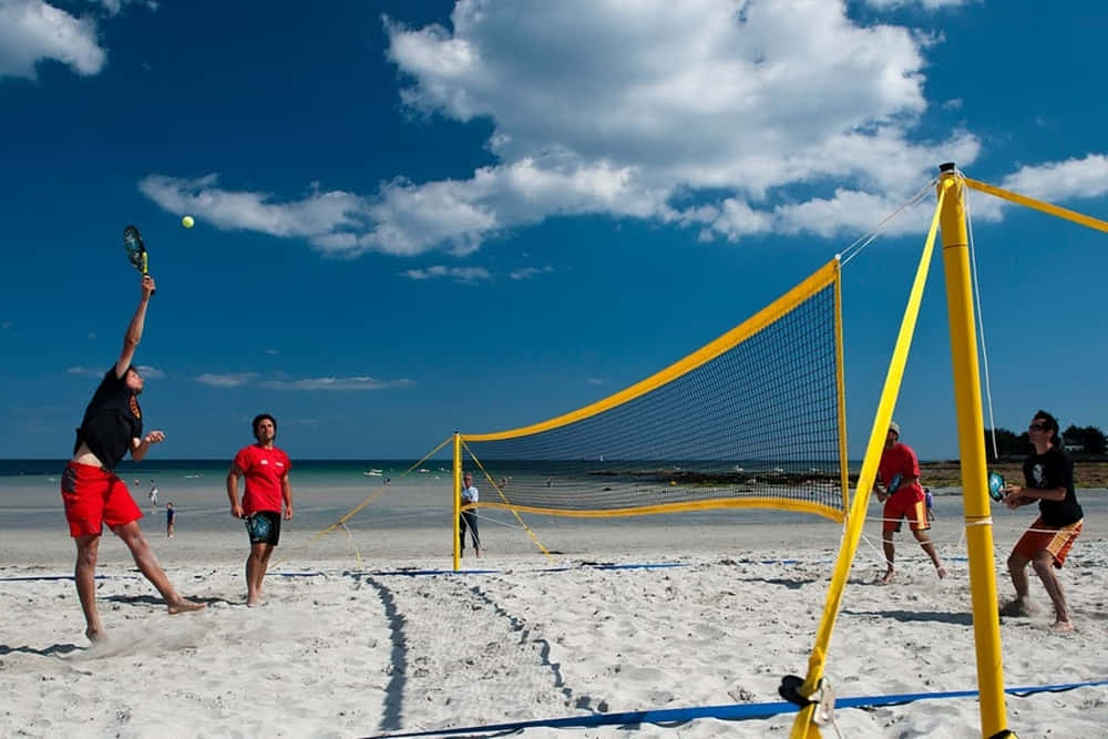 Caption: Exciting Beach Tennis Match In A Picturesque Coastal Setting Wallpaper