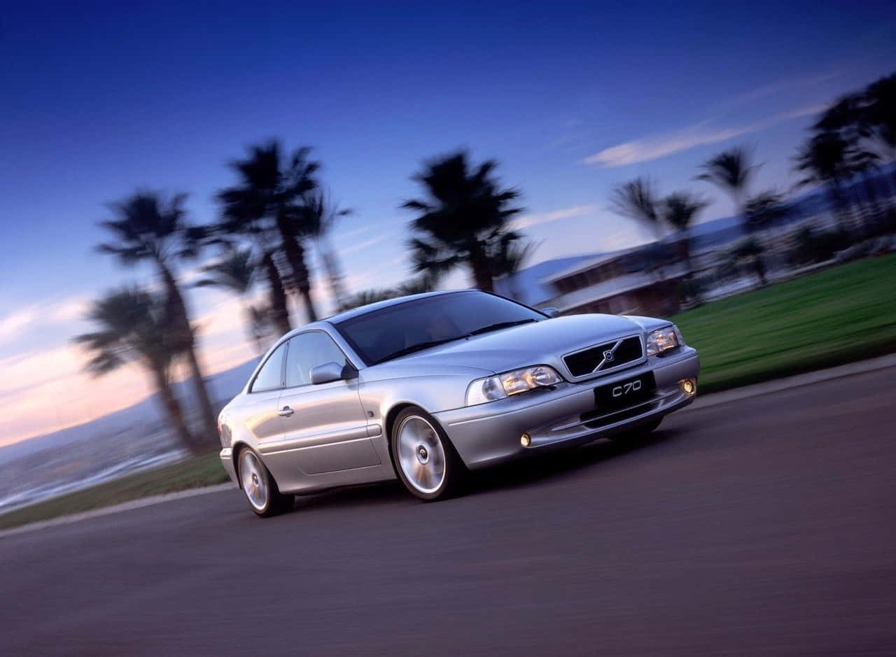 Caption: Graceful Volvo C70 Cruising On The Highway Wallpaper