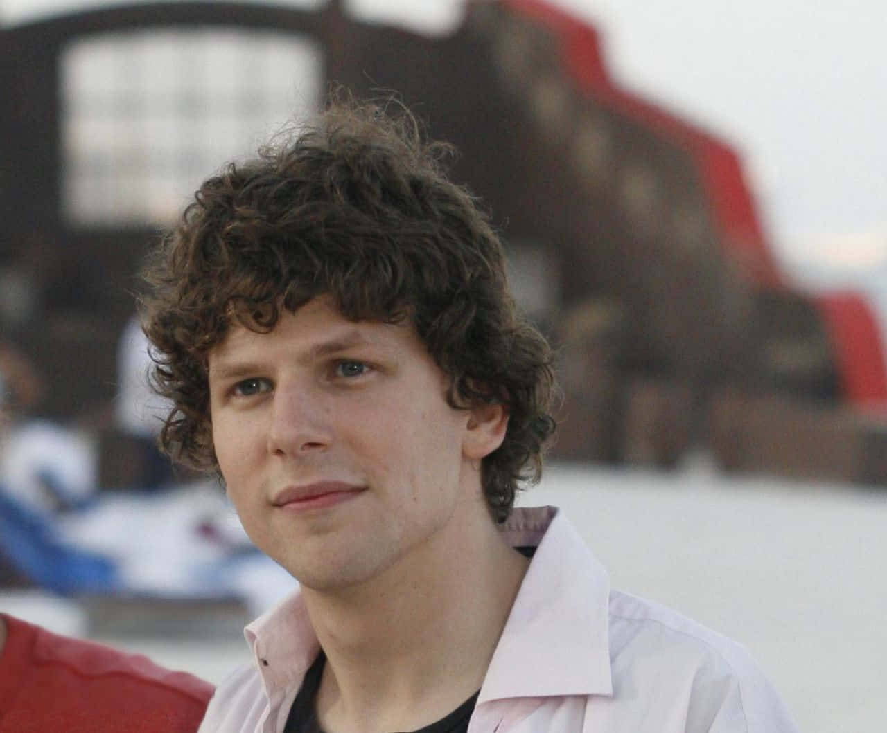 Caption: Hollywood Actor Jesse Eisenberg Gazing Into The Distance Wallpaper