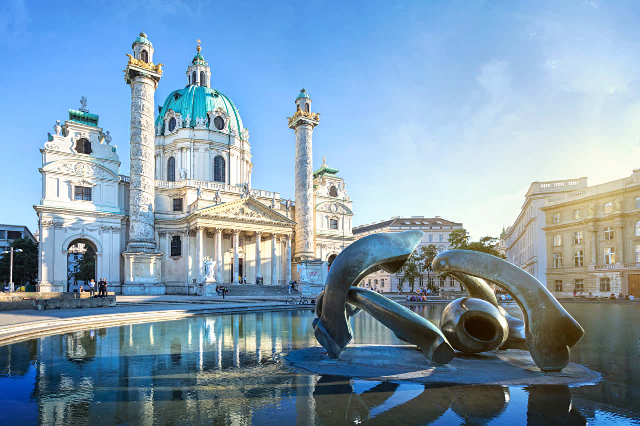 Caption: Majestic Vienna Cathedral Under The Clear Blue Sky Wallpaper