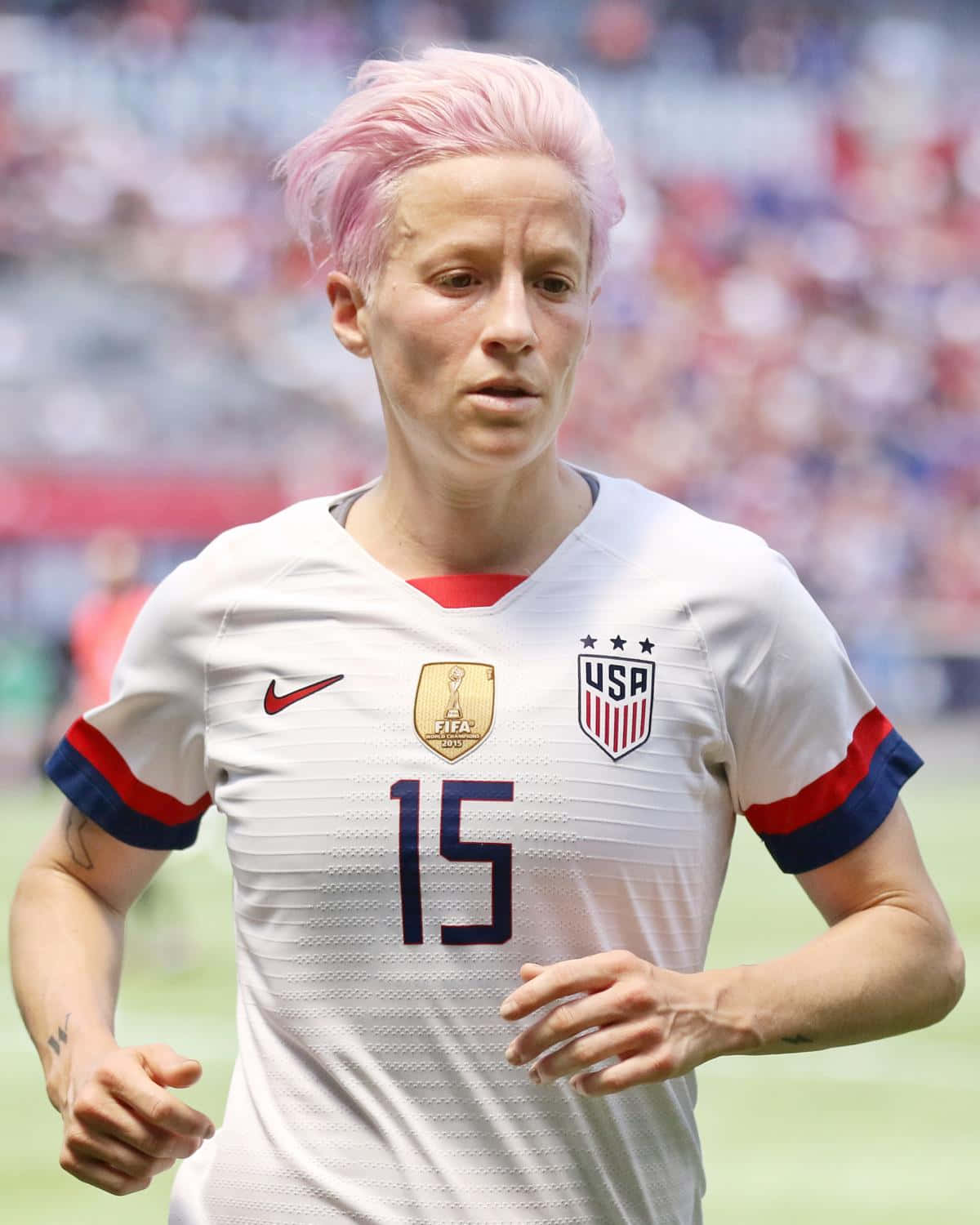 Caption: Megan Rapinoe Celebrating A Triumphant Win On Soccer Field Wallpaper