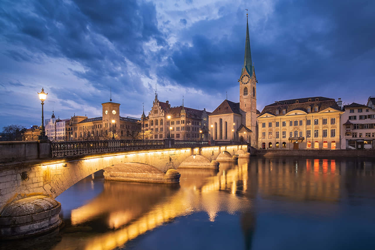 Caption: Mesmerizing Sunset Over Zurich’s Historic Skyline Wallpaper