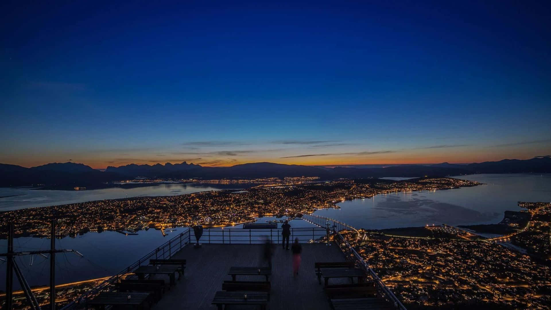 Caption: Picturesque View Of Tromso Under The Northern Lights Wallpaper