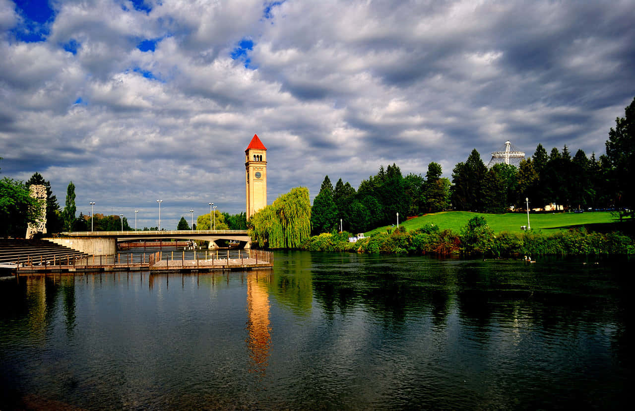 Caption: Scenic View Of Spokane River Amidst Lush Greenery. Wallpaper