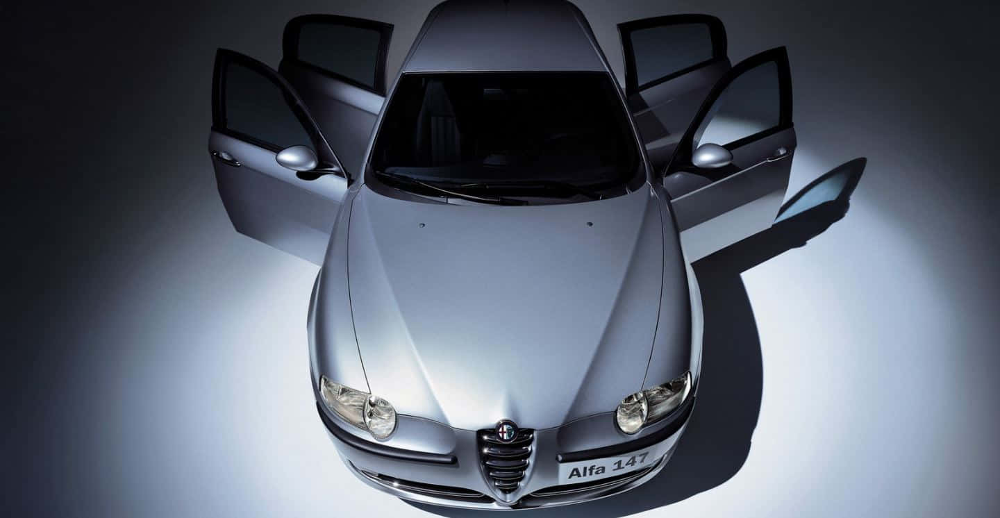 Caption: Sleek Alfa Romeo 147 In Red Wallpaper