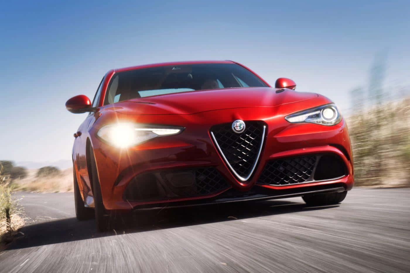 Caption: Sleek Alfa Romeo Giulia In Motion Wallpaper