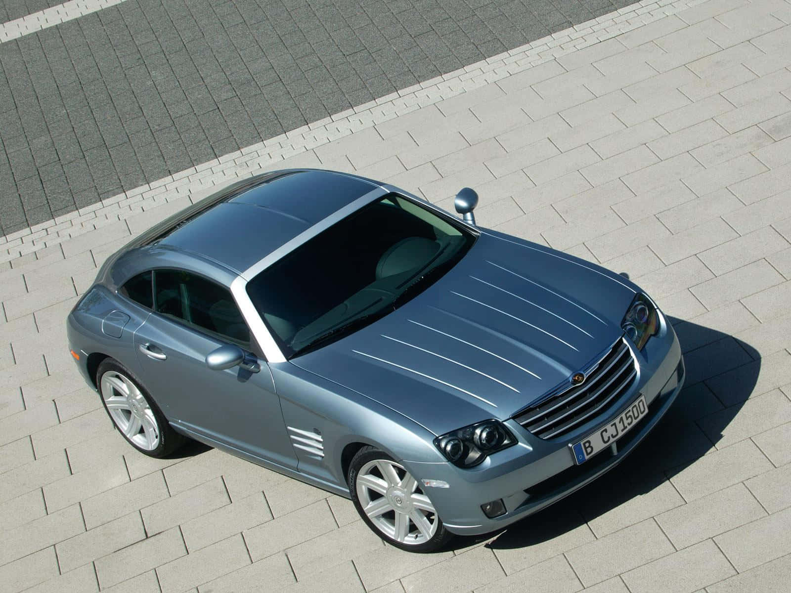 Caption: Sleek Chrysler Crossfire In A Vibrant Cityscape Wallpaper