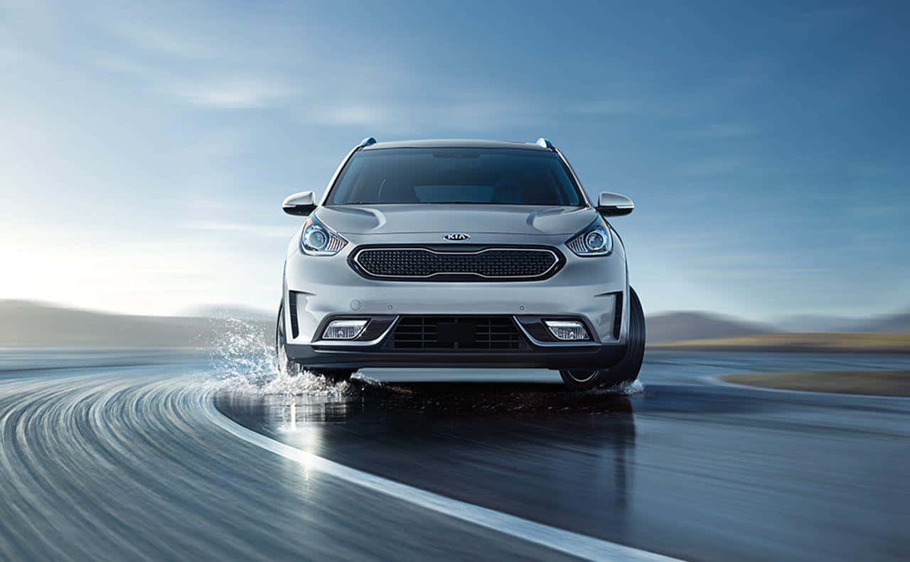 Caption: Sleek Kia Niro On A Scenic Drive Wallpaper