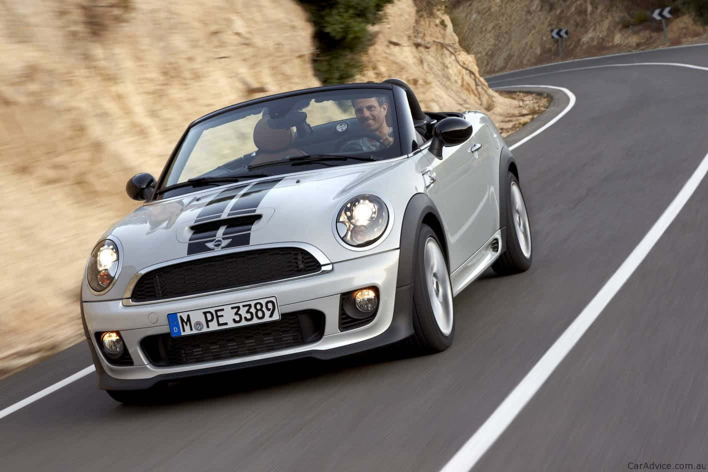 Caption: Sleek Mini Roadster Cruising Down The Highway Wallpaper