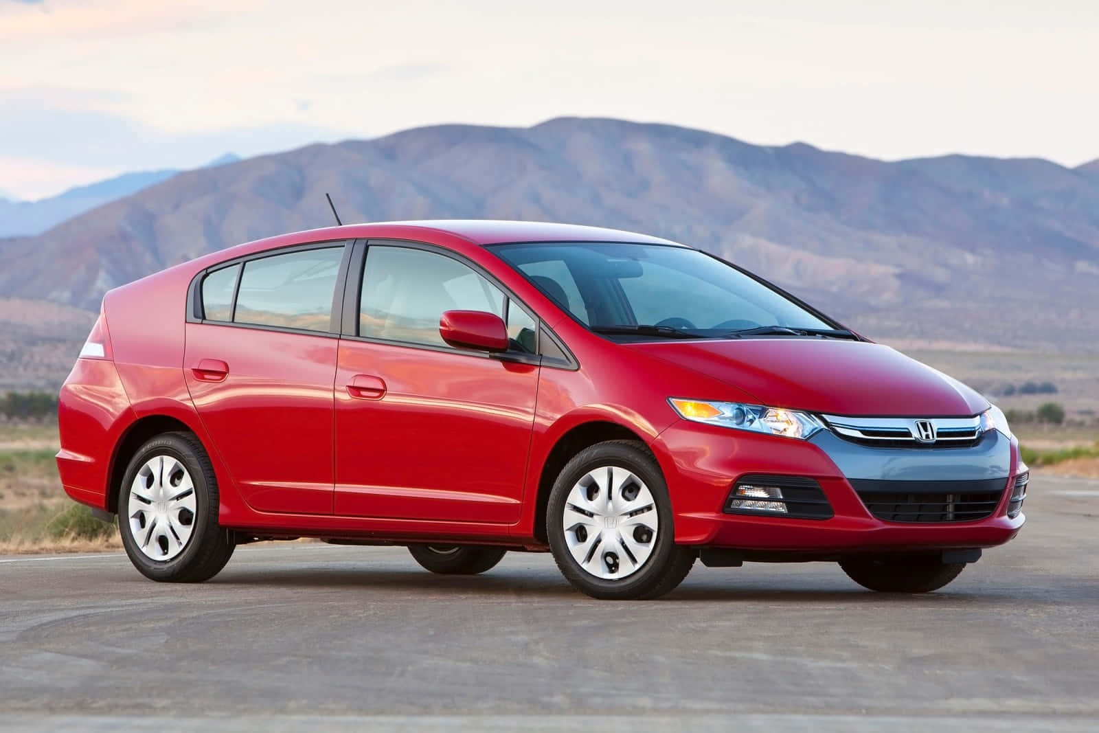 Caption: Sleek Red Honda Insight Hybrid On The Road Wallpaper