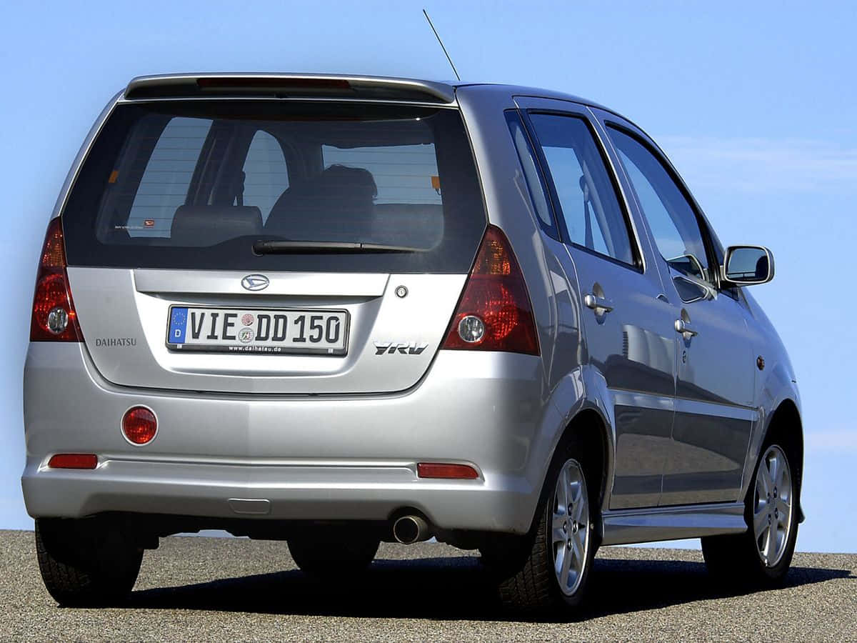 Caption: Sleek Silver Daihatsu Yrv On The Street Wallpaper