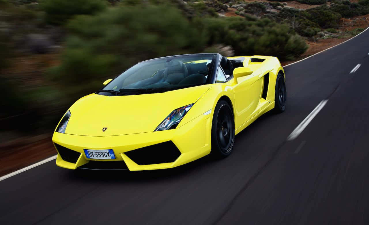 Caption: Sleek Yellow Car Cruising On Urban Streets Wallpaper