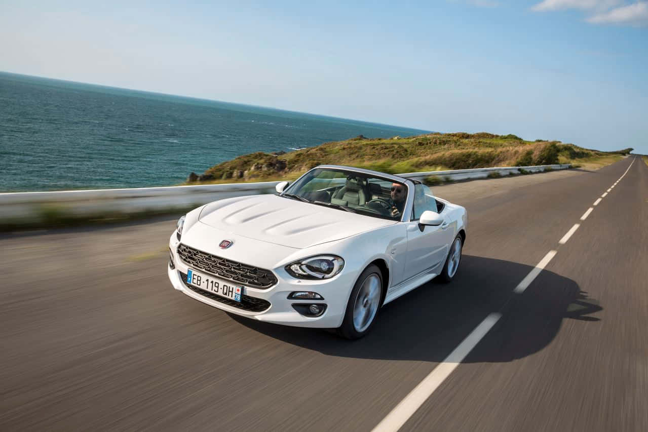 Caption: Stunning Fiat 124 Spider In Action Wallpaper