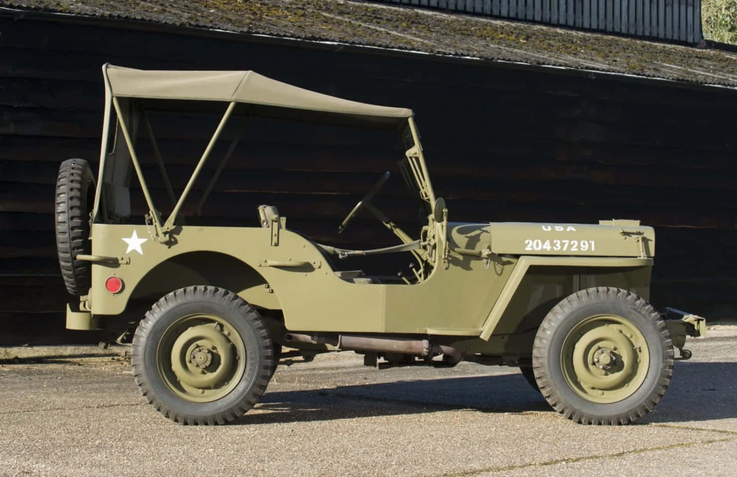 Caption: Vintage Jeep Willys In A Scenic Forest Setting Wallpaper