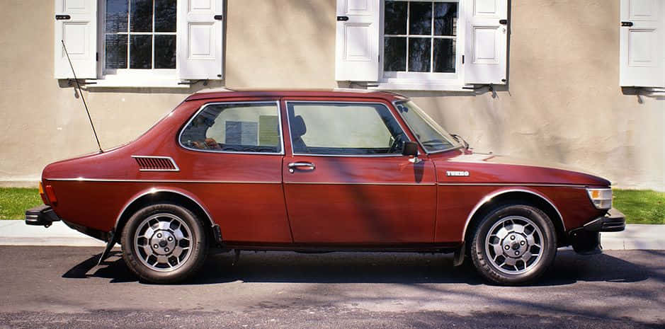 Caption: Vintage Saab 99 Car In Exciting Outdoor Setting Wallpaper