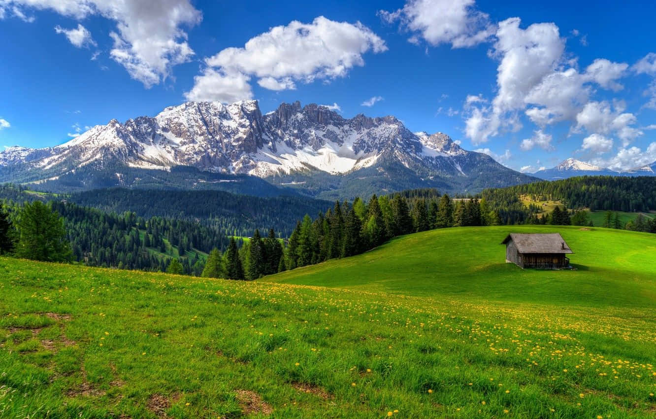 Captivating Spring Mountain Landscape With Lush Greenery And Blue Sky Wallpaper