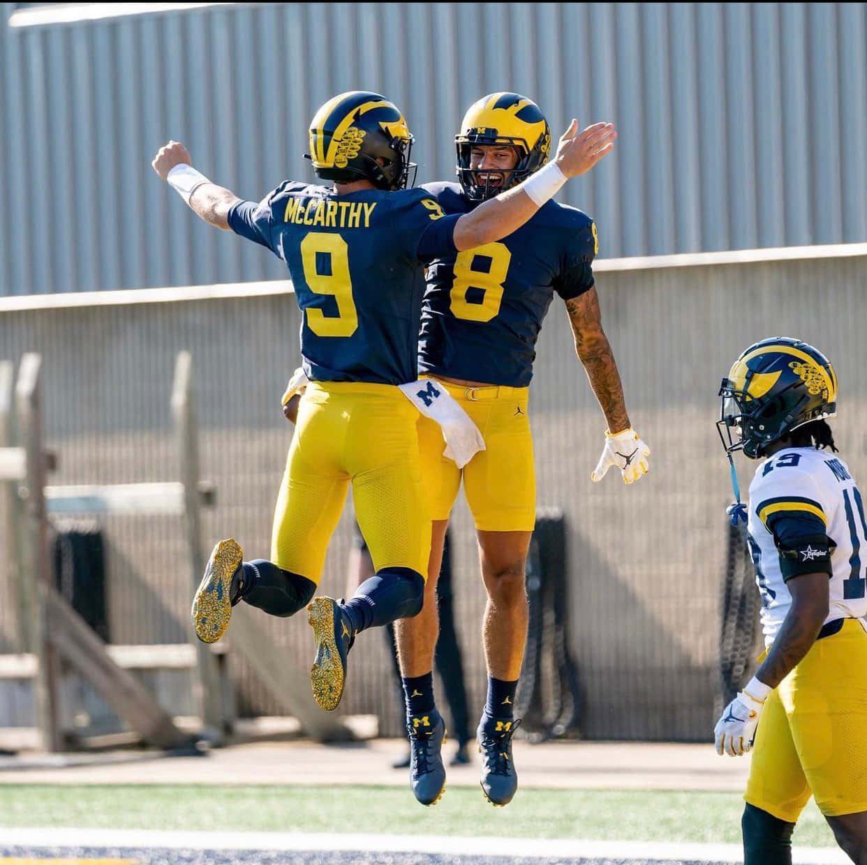 Celebratory Jump Michigan Football Players Wallpaper