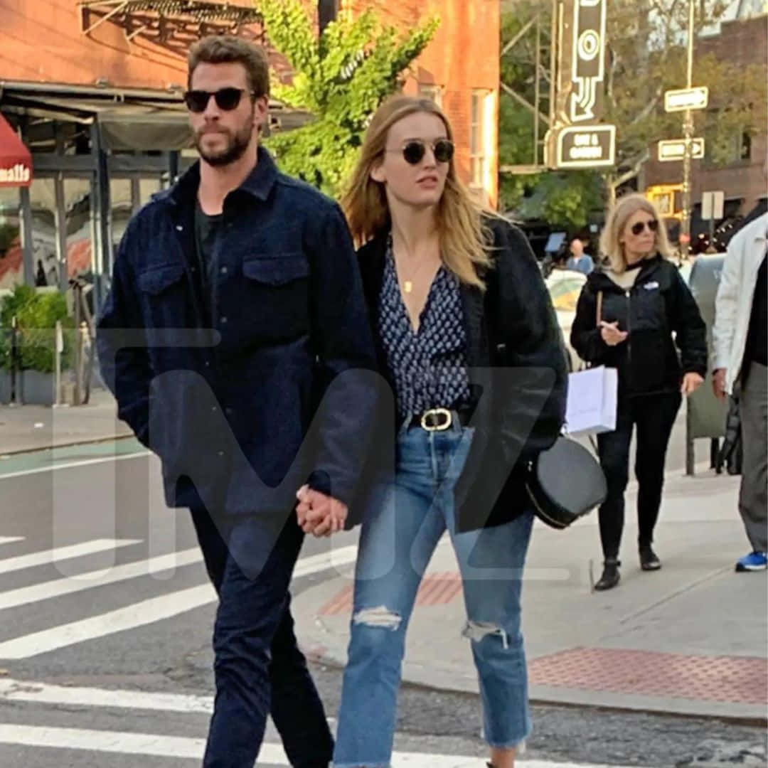 Celebrity Couple Walkingin City Wallpaper