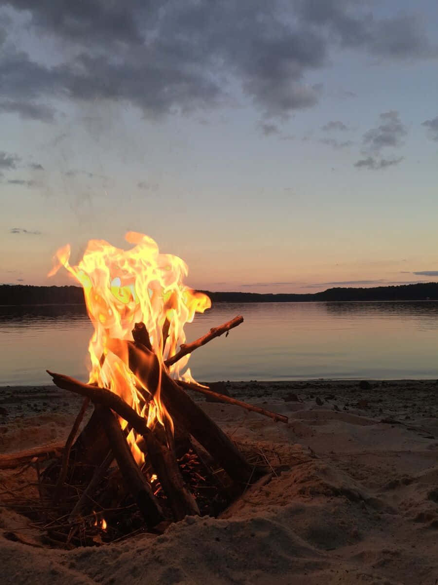 Charming Beach Campfire Under The Starlit Sky Wallpaper