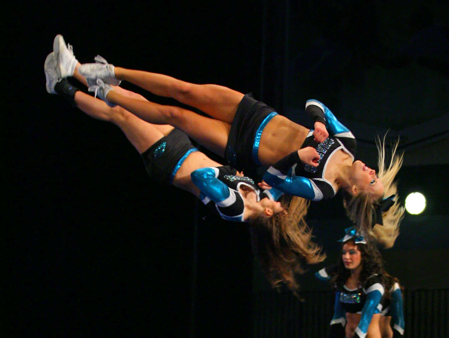 Cheerleaders In Mid Air Stunt Wallpaper