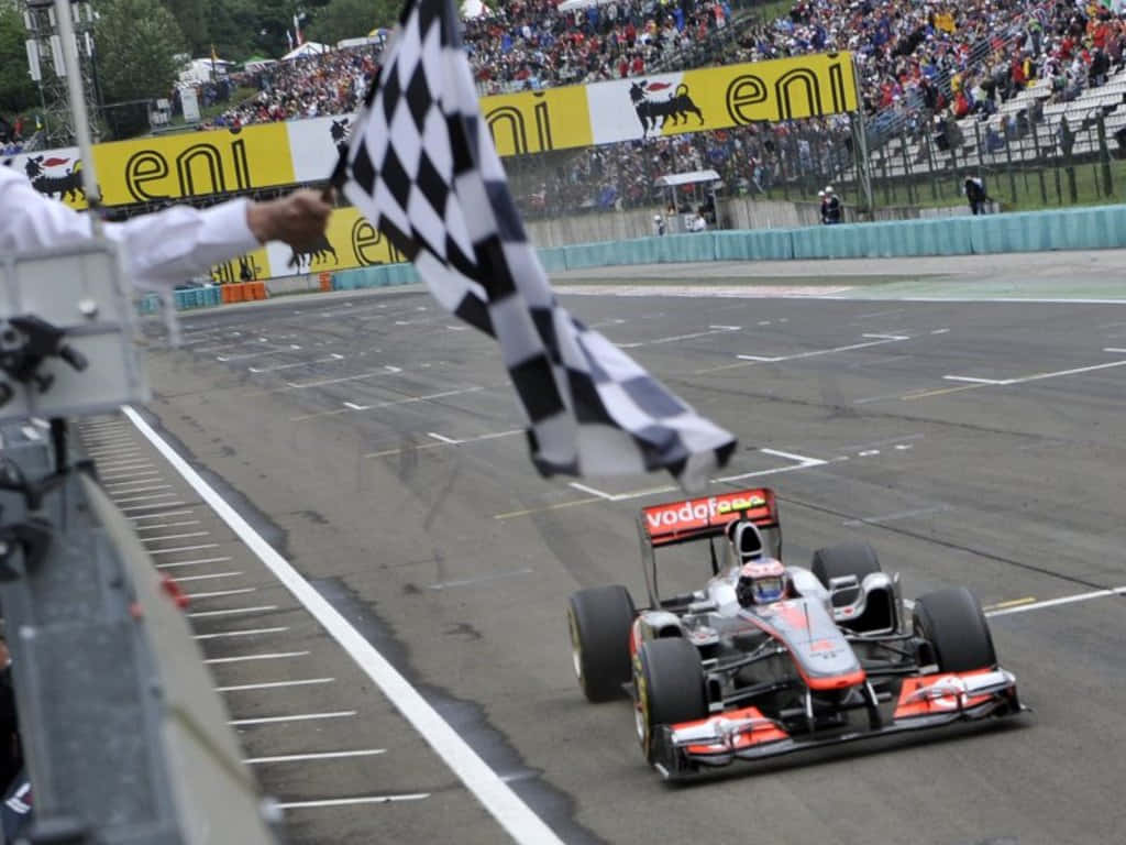 Chequered Flag Waving On A Racetrack Wallpaper