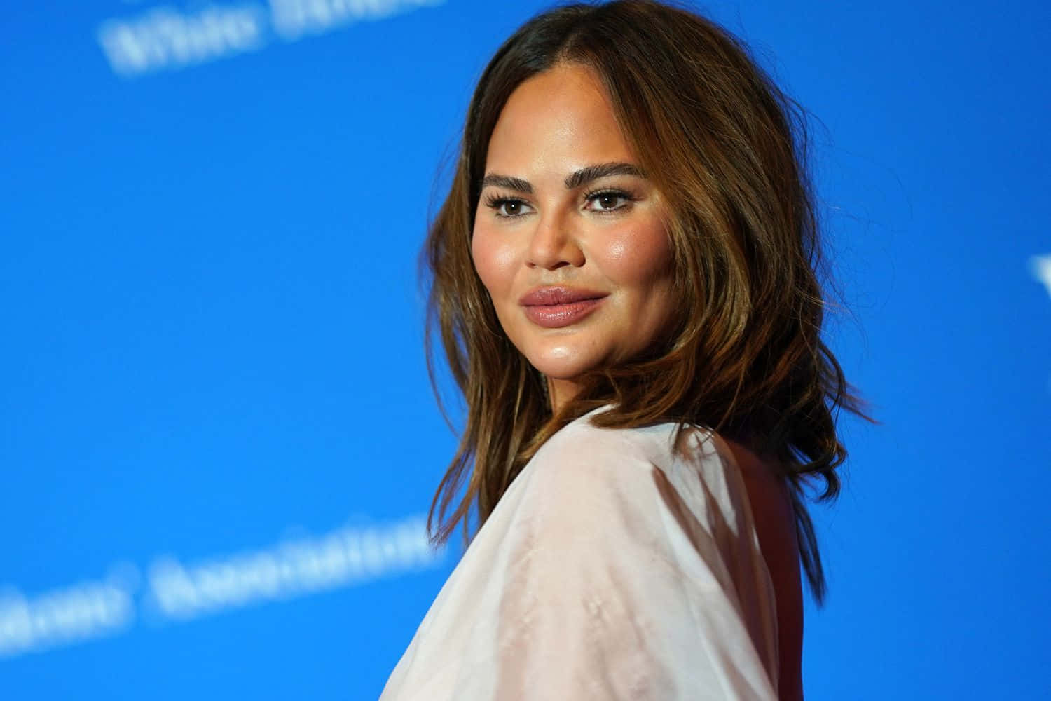 Chrissy Teigen Blue Backdrop Event Wallpaper