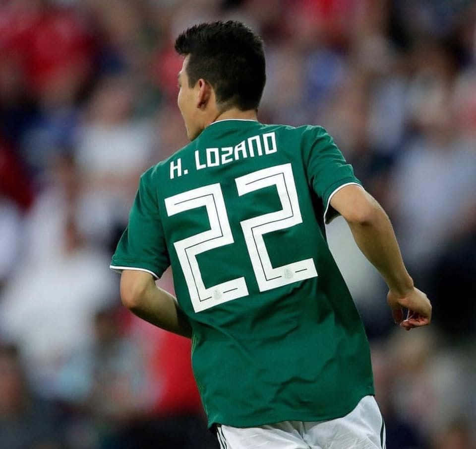 Chucky Lozano Dribbling On The Soccer Pitch Wallpaper