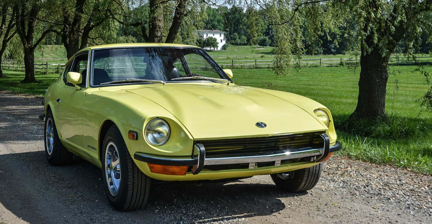 Classic Datsun 240z In Pristine Condition Against A Stunning Sunset Backdrop. Wallpaper