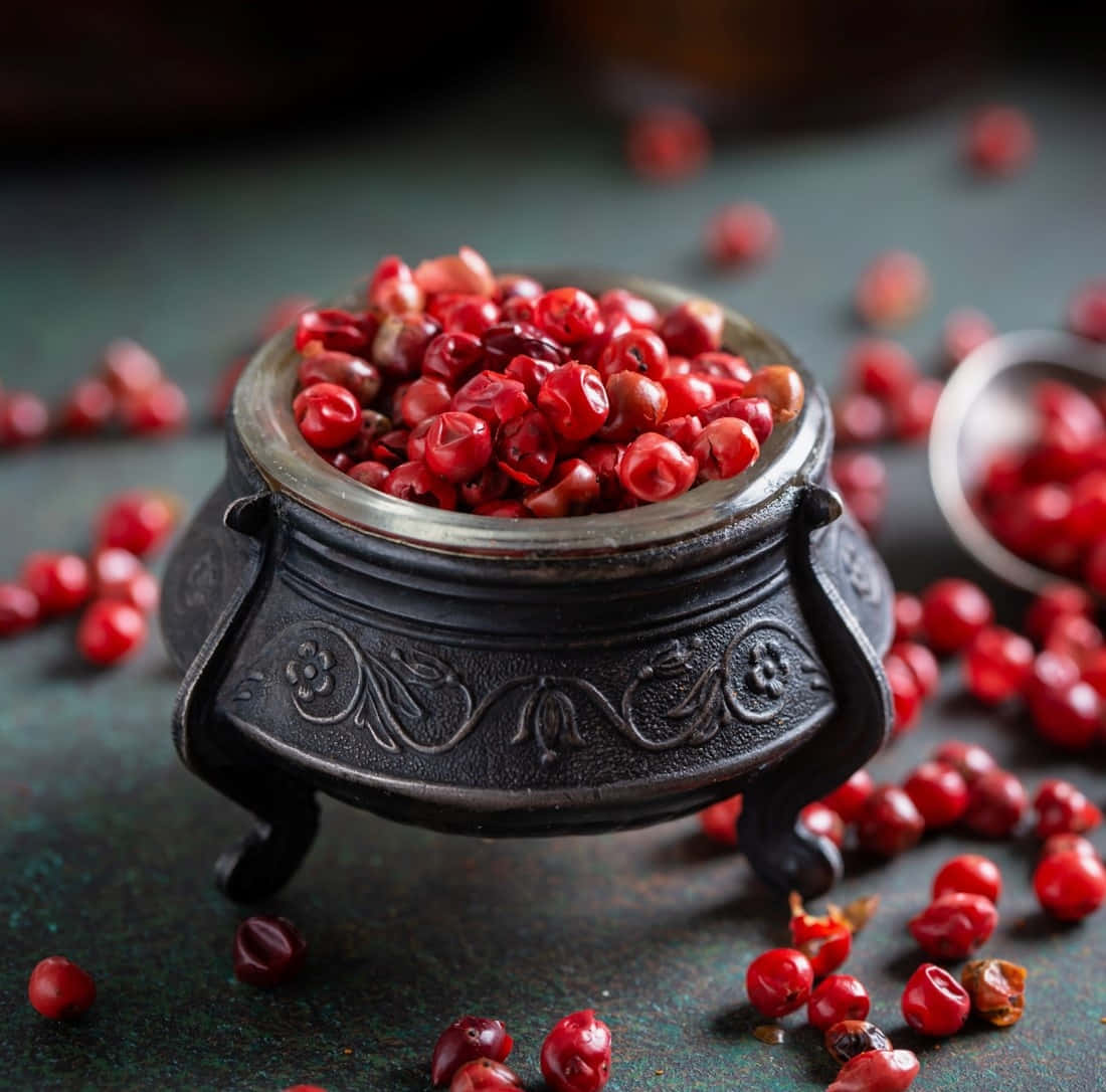 Close-up Of Pink Peppercorns On Wooden Surface Wallpaper