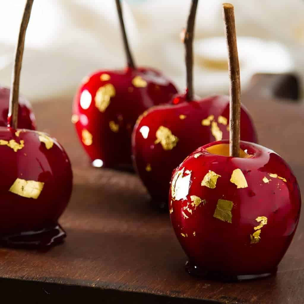 Colorful And Delicious Candy Apples On Wooden Table Wallpaper